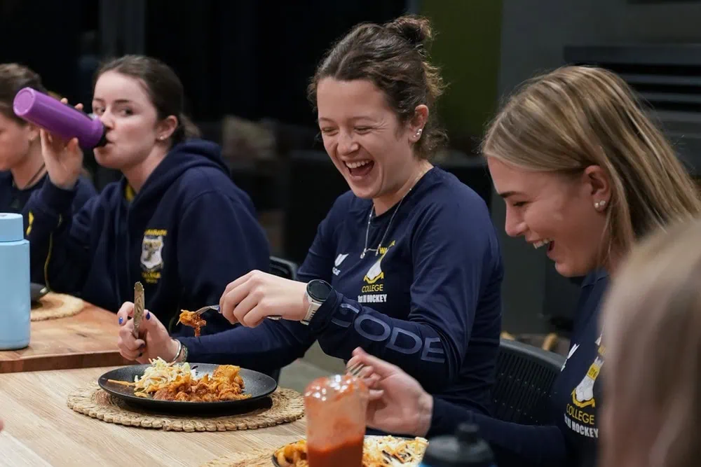 School girls hockey team enjoying a meal together while staying at Kiwiesque.