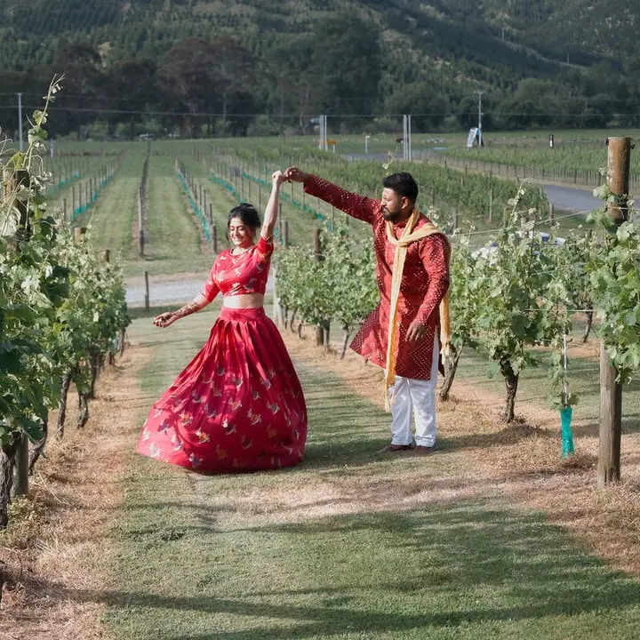 Bride and groom dancing among the vines at traditional indian wedding at Kiwiesque
