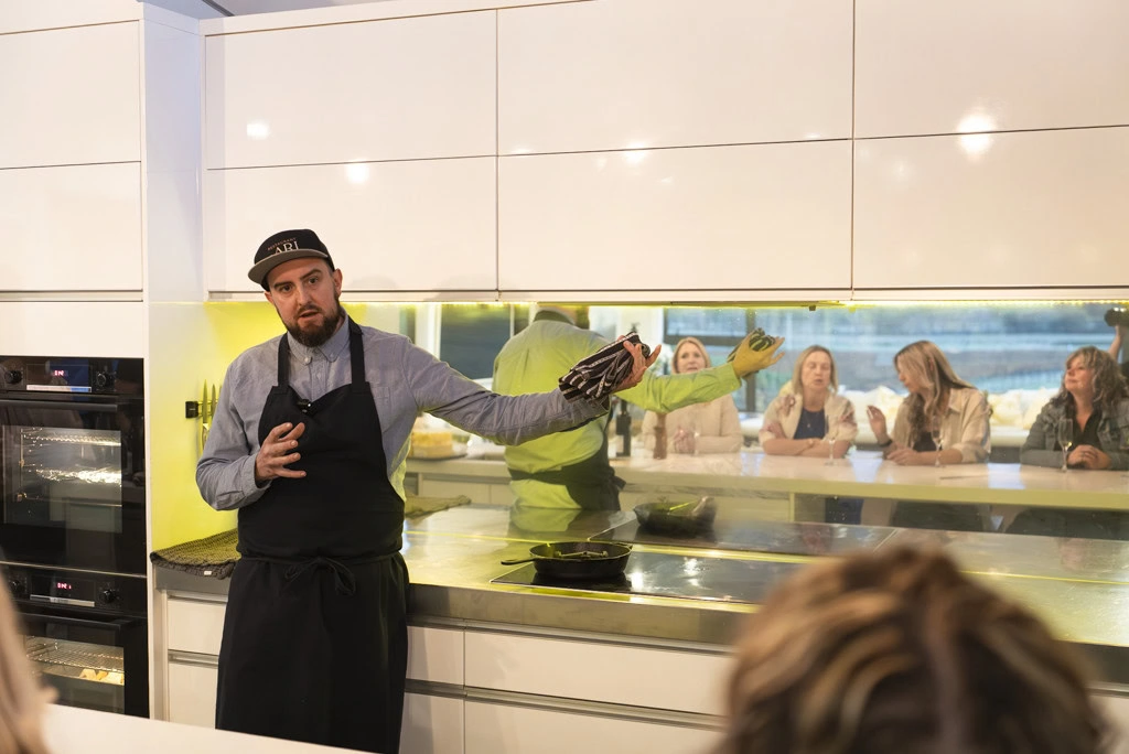 Chef Simon Lillico talking in the kitchen to a group of guests at a Kiwiesque Winter Food and Wine Experience