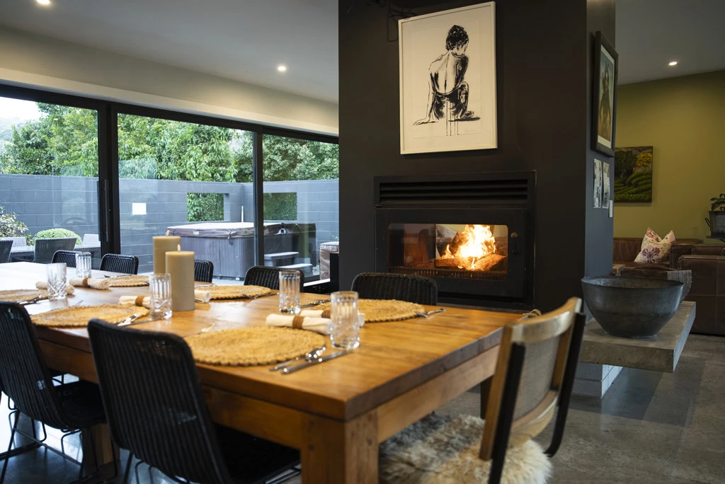 A set dining table in front of roaring fire at a Kiwiesque Winter Food and Wine Experience