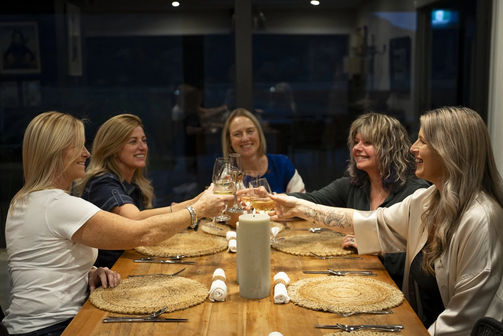 Group of ladies sitting at dining table raising a toast at a Kiwiesque Winter Food and Wine Experience